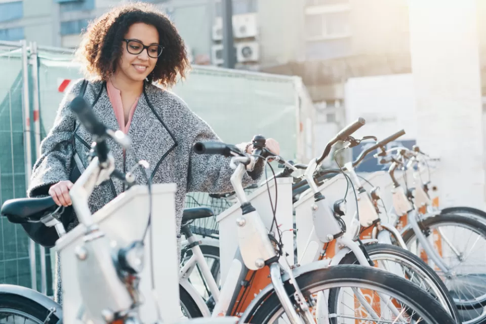Woman accessing bike at bike share station